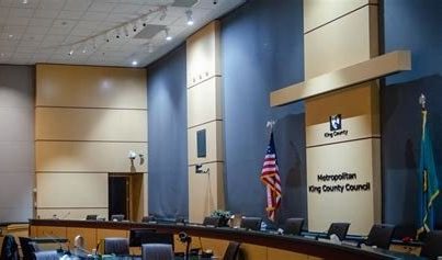 King County Council chambers with an American flag and empty chairs
