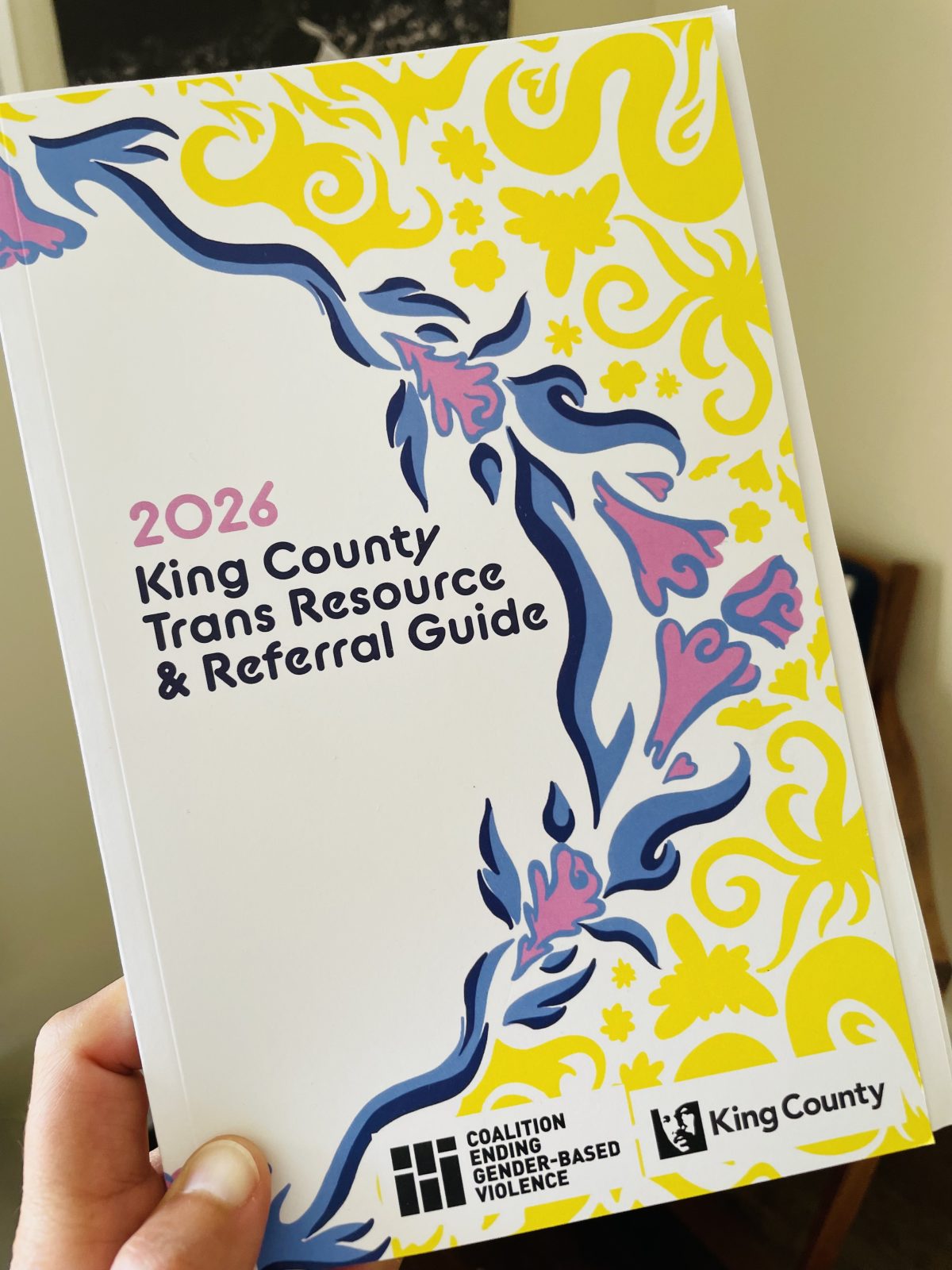 a trans resource adn referral guide book with yellow, pink and blue flowers